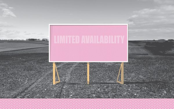 A pink billborad stands in an agricultural field, it says 'Limited Availability'.