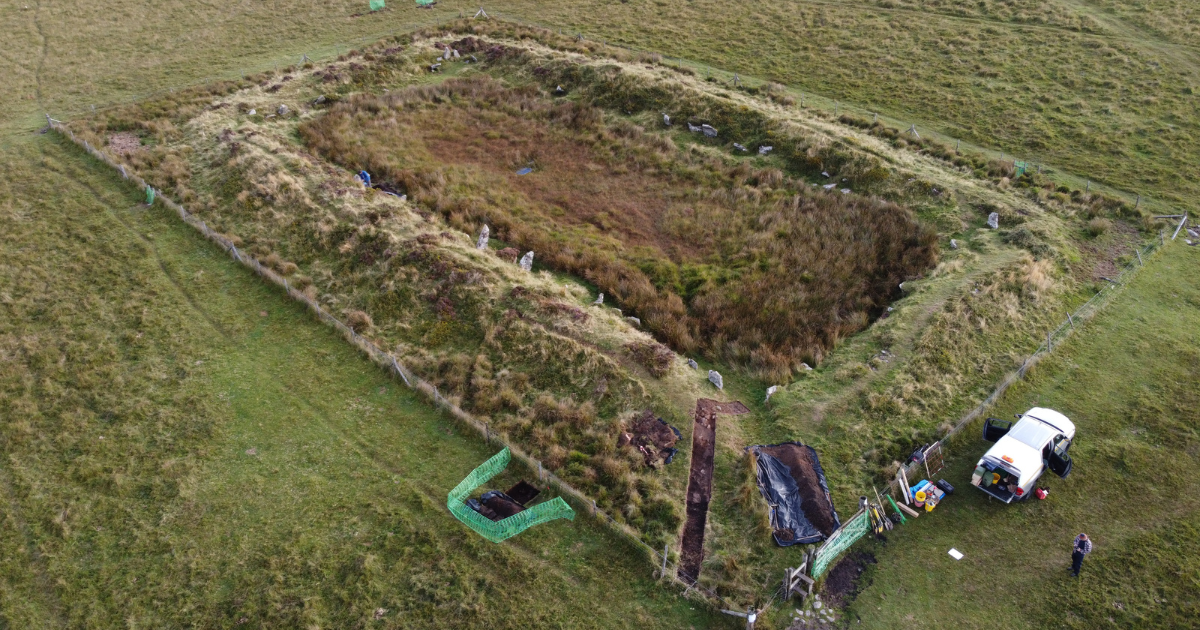 A view of a rectangular earth mound from above.